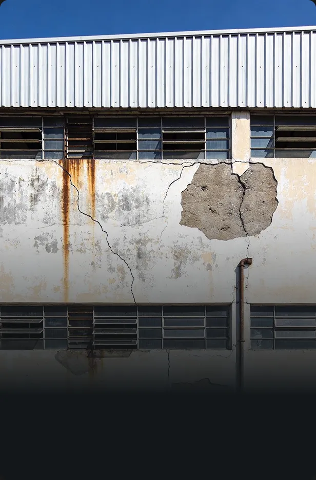 Fachada industrial com fissuras antes da pintura