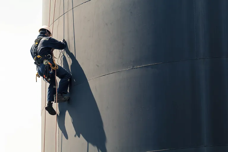 Trabalhador aplicando pintura anticorrosiva em estrutura metálica industrial